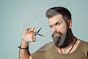 Stylish bearded man. Barber holding scissors. Small business, barber shop. Handsome hairstylist. Mens haircut, beard care