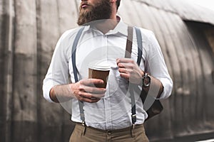 Stylish bearded man on coffee break holding disposable cup