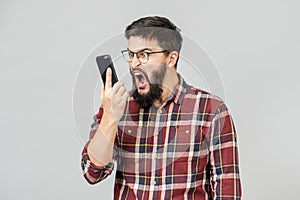Stylish bearded man with dark hair angry shouting on the phone