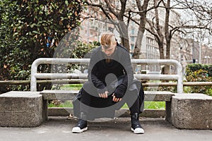 Stylish bearded man sitting on a bench