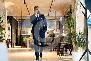 Stylish bearded man in a suit standing in modern office