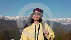 Stylish beautiful brunette travel woman in sunglasses walking at snowy mountain nature landscape