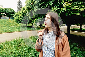 Stylish beautiful hipster girl holding dandelion and having fun