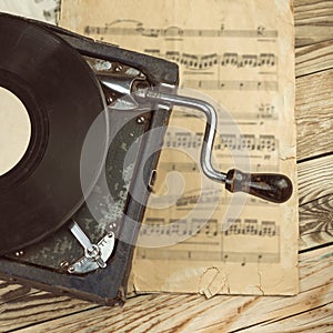 Stylish beautiful old gramophone with manual winding on a wooden table.