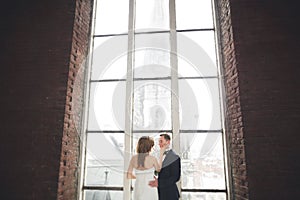 Stylish beautiful wedding couple kissing and hugging on background panoramic view of the old town