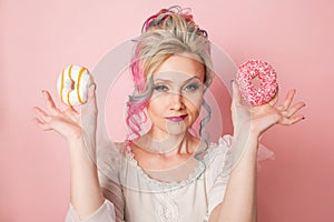 Stylish and beautiful woman with colored hair with Two donuts, glamour pink style