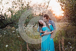 Stylish beautiful young couple standing outdoors at sunset light