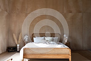 Stylish Bedroom corner with rattan headboard and bed with soft pillows setting with white pillows plywood wall on the background