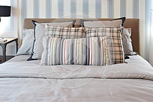 Stylish bedroom interior with striped pillows on bed