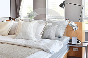 Stylish bedroom interior with white striped pillows on bed