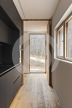 Stylish black kitchen with large windows to nature