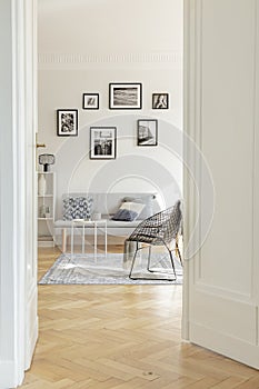 Stylish black metal chair in classy white living room interior with tenement house