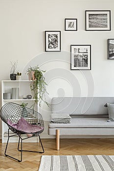 Stylish black metal chair in classy white living room interior with tenement house