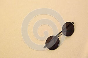 Elegante negro gafas de sol alrededor anteojos descansa sobre el frazada hecho de suave esponjoso la luz naranja tela. de moda 