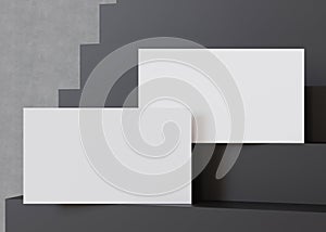 Stylish blank, white business cards on a cascading black staircase, perfect for a bold and modern branding presentation