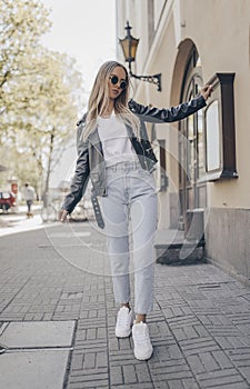Stylish blogger posing in the street, wearing jacket photo