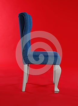 Stylish blue chair on red background