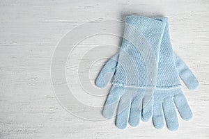 Stylish blue gloves on white wooden background, top view. Autumn clothes