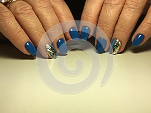 Stylish blue manicure with a festive golden design