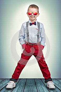 Stylish boy in fashionable clothes and sunglasses from the sun . Children`s fashion.