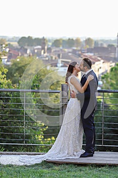 Stylish bride and groom at a park on their wedding day. Beautiful love story in nature, couple in love