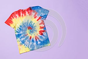 Stylish bright tie dye T-shirt on a purple background