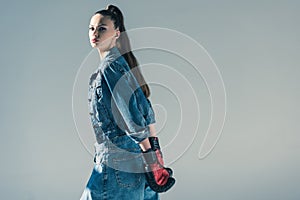 stylish brunette girl in denim clothes and boxing gloves