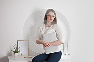 Stylish business brunette in glasses with laptop.