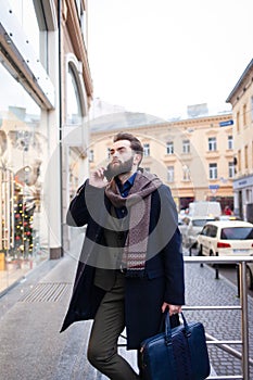 Stylish business man with a beard talking on the phone with business partners