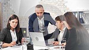 Stylish business people wearing suit talking with male teamleader having team meeting at office