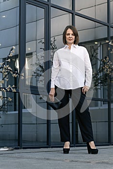 Stylish business woman in formal clothing. Formal shirt and black clutch. Casual style