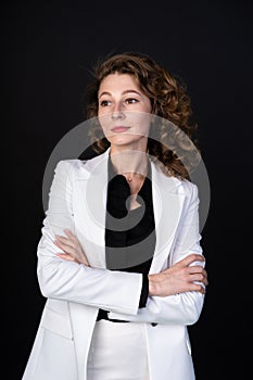 Stylish business woman in white suit standing with arms folded, she is calm and confident, vertical