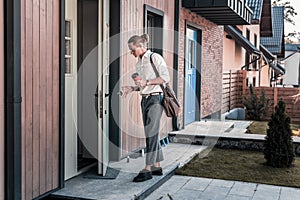 Stylish businessman holding keys while entering his house after work