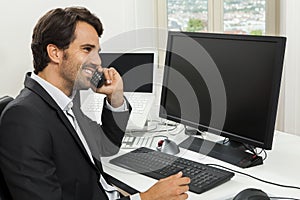 Stylish businessman in a suit sitting at his desk