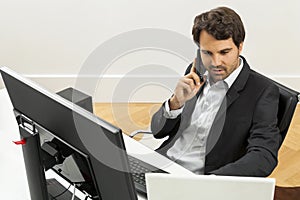 Stylish businessman in a suit sitting at his desk