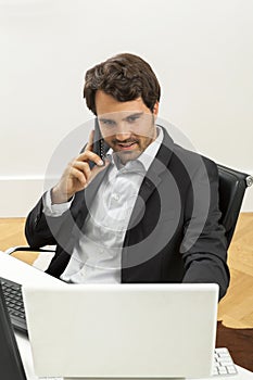 Stylish businessman in a suit sitting at his desk