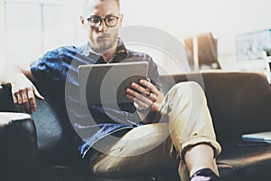 Stylish businessman working tablet PC modern Interior Design Loft Office.Man relax Vintage sofa use contemporary device