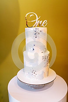 Stylish cake for first birthday with silver inscription one. cake for children`s birthday. selective focus