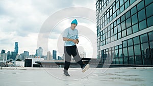 Stylish caucasian dancing man performing break dance at skyscraper. Endeavor.