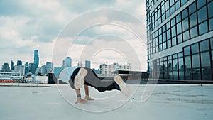 Stylish caucasian dancing man performing break dance at skyscraper. hiphop.