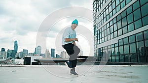 Stylish caucasian dancing man performing break dance at skyscraper. hiphop.