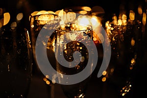 Stylish champagne glasses empty on background of warm romantic candle light at evening wedding ceremony