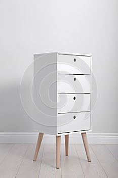 Stylish chest of drawers near white wall. Furniture for room