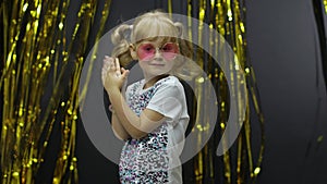 Stylish child dancing, make faces, shaking shoulders in silly dance. Little kid girl 4-5 years old