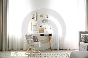 Stylish child`s room interior with desk and pictures