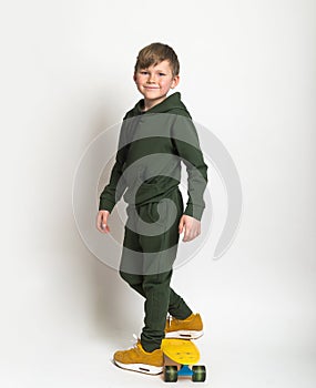 Stylish children. Fashionable portrait of a little school boy dressed in sports sport suit hoodie yellow sneakers. Boy