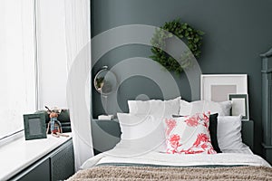 Stylish Christmas bedroom. Pillows on the bed and a wreath on the wall