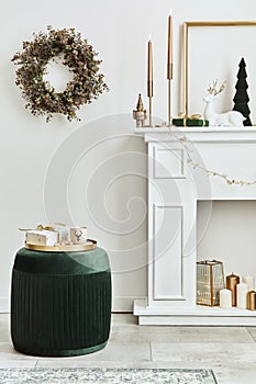 Stylish christmas composition at living room interior with white chimney, christmas tree and wreath, stars, gifts and decoration.
