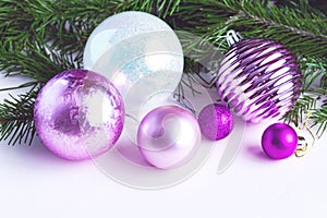 Stylish Christmas composition of Purple balls on a white background near a fir branch