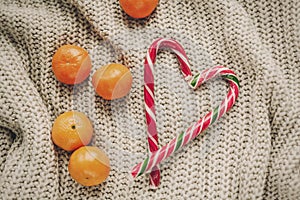 Stylish christmas flat lay. peppermint candy cane in heart shape